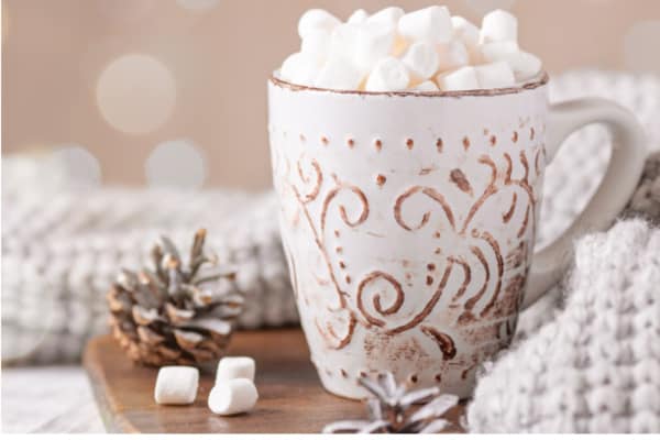 mug of cocoa with marshmallows and soft blanket for a hygge holiday